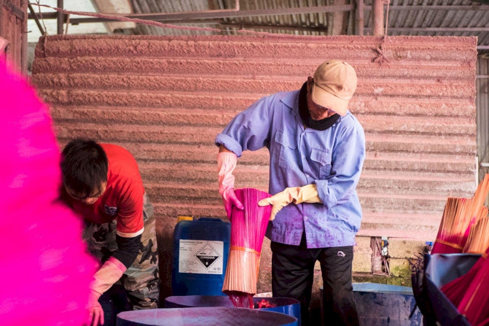 Artisans carefully dye incense sticks by hand